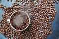 Roasted coffee beans texture with coffee beans scattered on dark background and white cup Ã¢â¬â top view Royalty Free Stock Photo